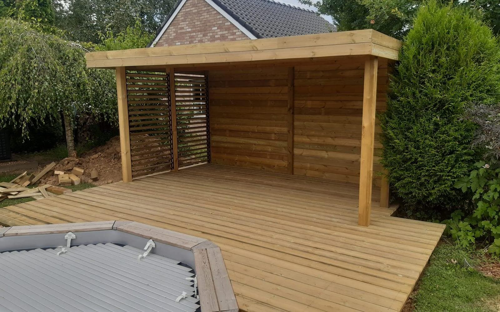 Pergola bois et terrasse terminées autour de la piscine